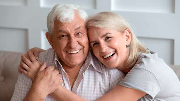 A Portrait Of Happy Old Couple Looking At Camera And Smiling