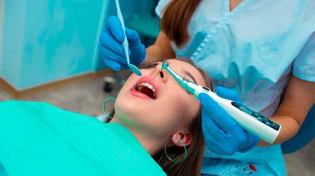 A Young Beautiful Female Dentist Examining Teeth Of A Female Patient